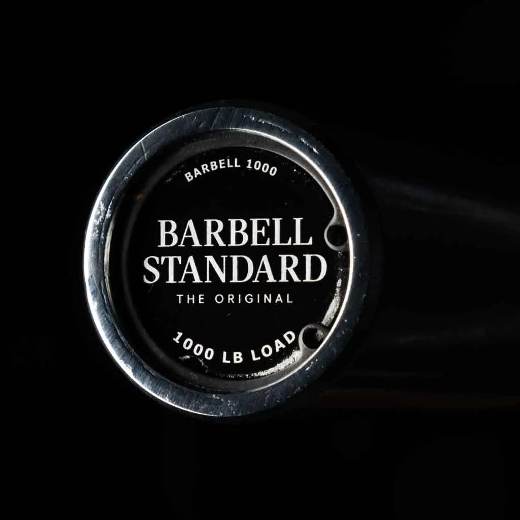 Barbell Standard 1000 Compact Barbell with adjustable weight plates and sturdy metal construction for strength training.