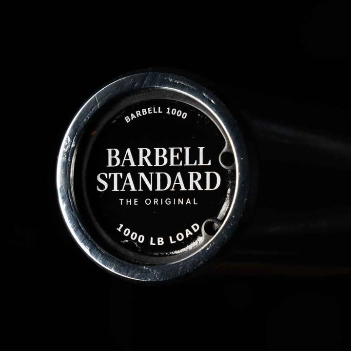 Barbell Standard 1000 Compact Barbell with adjustable weight plates and sturdy metal construction for strength training.