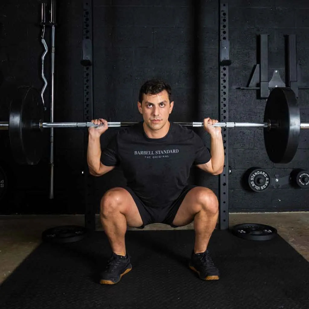 Barbell Standard 1500 Olympic barbell with metal collars, black finish, and knurled grip for weightlifting and strength training.