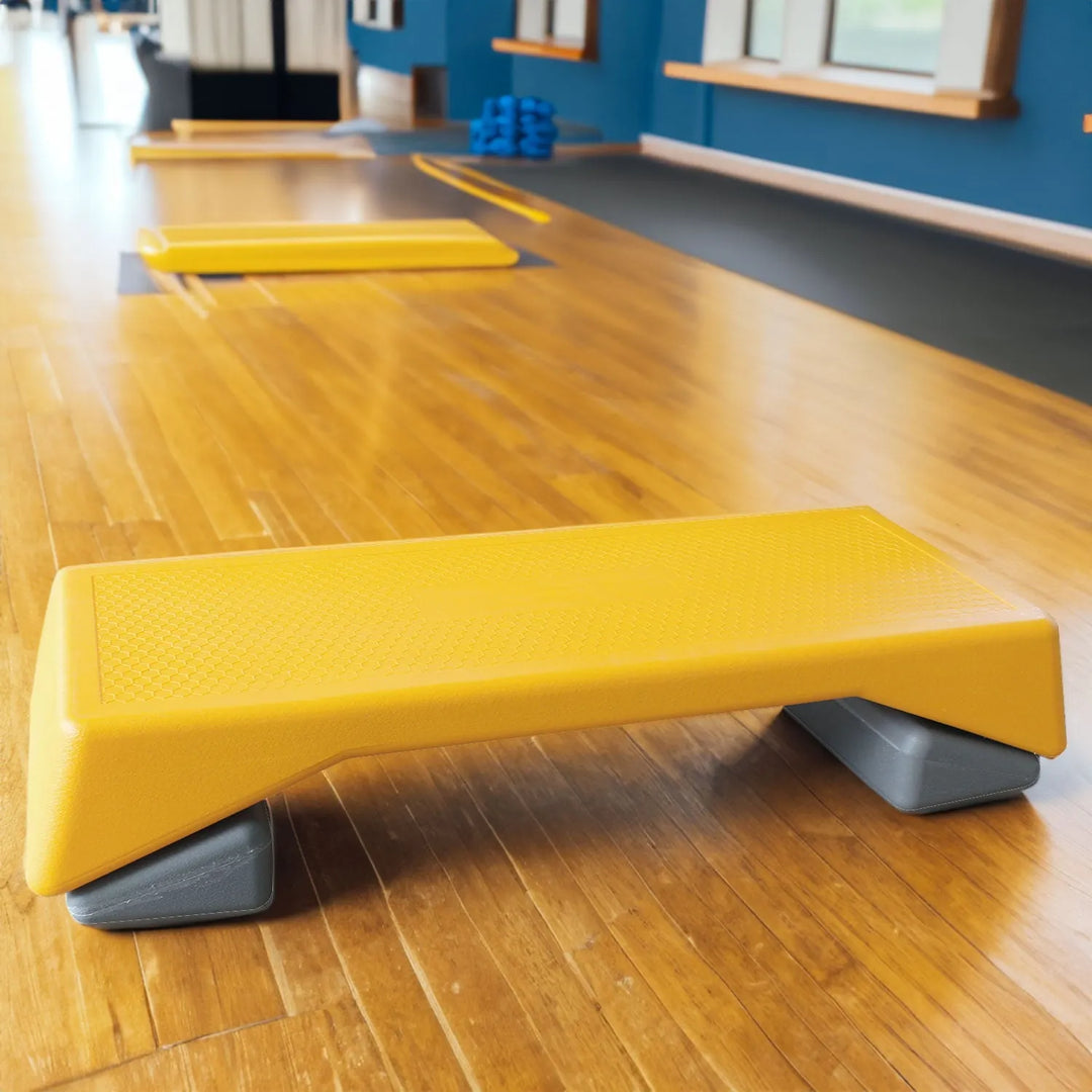 Yellow adjustable aerobic step platform for home workouts by V.I.P Digital Presence, featuring non-slip surface and height options.