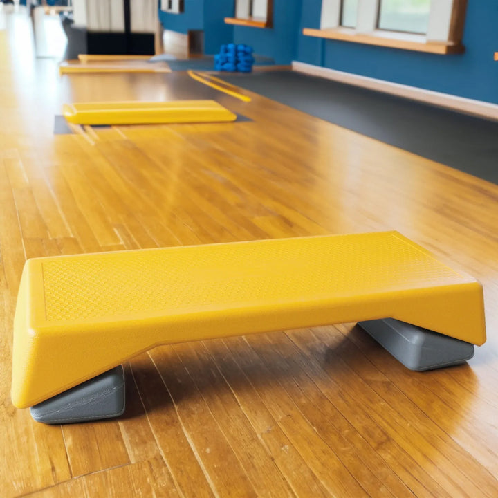 Yellow adjustable aerobic step platform for home workouts by V.I.P Digital Presence, featuring non-slip surface and height options.