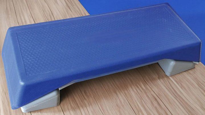 Blue aerobic step platform by V.I.P Digital Presence, sturdy plastic platform with textured surface for cardio workouts.