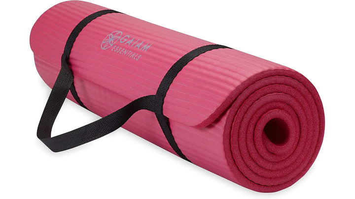 Pink Gaiam Essentials yoga mat by The Peak Pivot, showing textured surface and thickness for comfortable yoga practice.