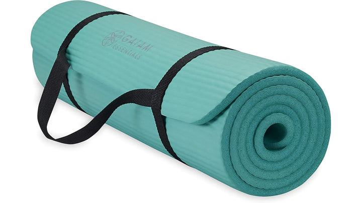 Teal Gaiam Essentials yoga mat by The Peak Pivot, textured surface for grip, rolled out on a yoga studio floor.