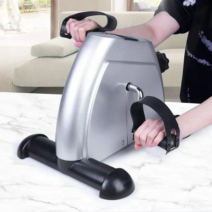 Adjustable mini exercise bike from The Peak Pivot designed for under-desk use, with pedals and compact frame for seated workouts.
