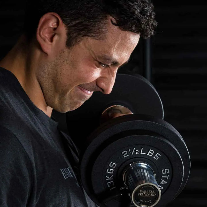 Pair of Barbell Standard loadable dumbbell bars with weight plates, suitable for strength training and adjustable weight lifting.